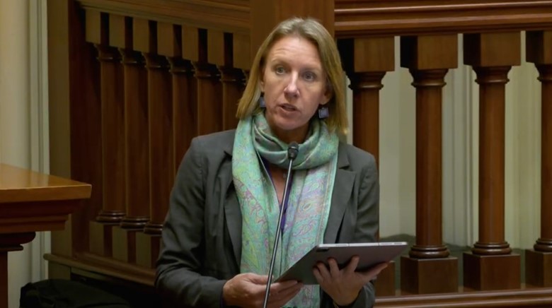Video still of Senator Blakespear speaking at podium.